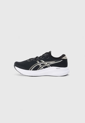 Chaussure de sport noire avec un dessus en maille texturée, des accents argentés, une semelle intermédiaire blanche et une semelle en caoutchouc. Présente un design à lacets.