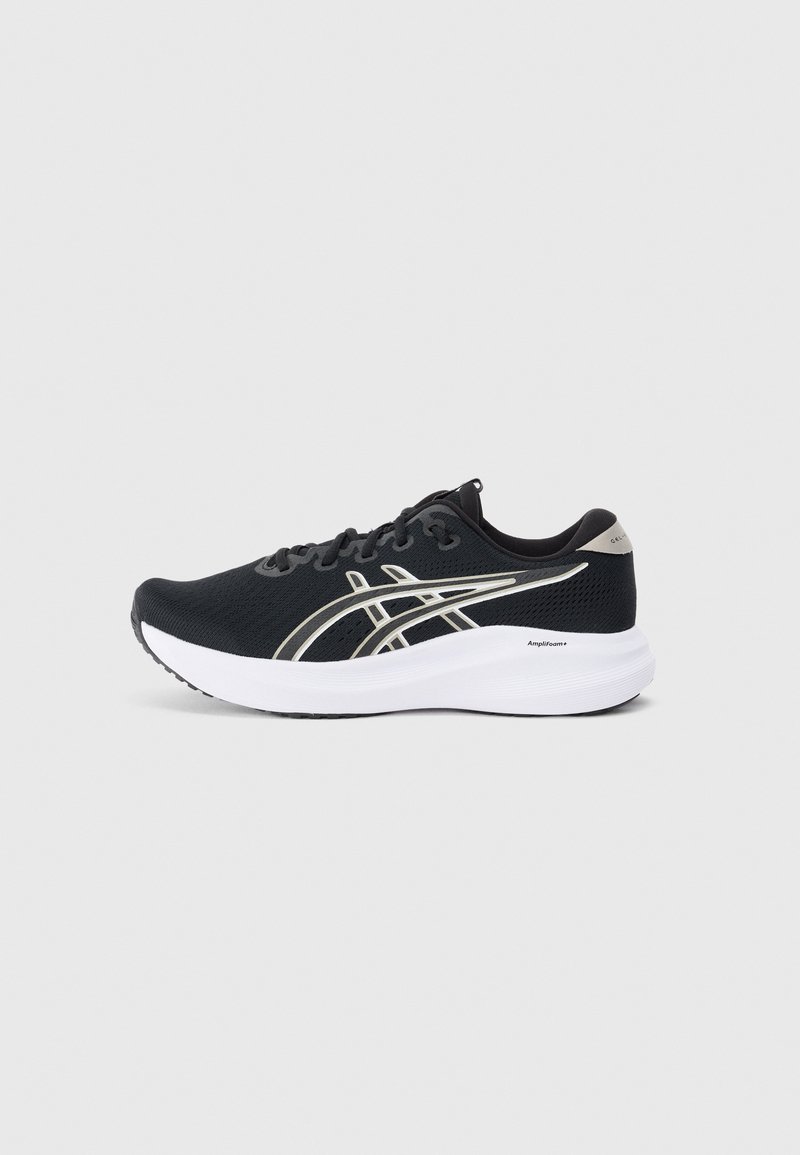 Chaussure de sport noire avec un dessus en maille texturée, des accents argentés, une semelle intermédiaire blanche et une semelle en caoutchouc. Présente un design à lacets.
