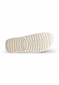 Witte rubberen schoenzool met getextureerde richels, met een cirkelvormig logo en een ronde neus. Gladde oppervlakte met duidelijke patronen voor grip.