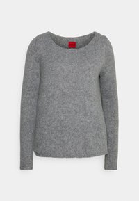 Pull gris à manches longues en maille côtelée ; il présente un encolure dégagée et une surface subtilement texturée. Étiquette de marque visible en rouge.