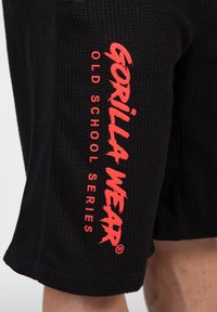 Black shorts with a textured fabric. Red "GORILLA WEAR" logo and "OLD SCHOOL SERIES" text printed vertically on the left side.