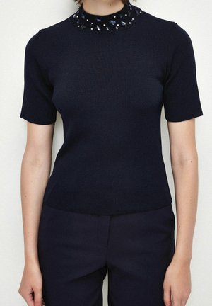 Marineblå strikket top med korte ærmer og en dekorativ perlehals, med en tætsiddende silhuet og glat tekstur.