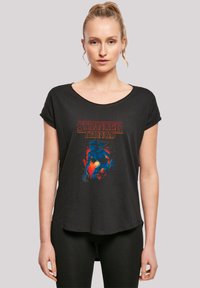 Black short-sleeve t-shirt featuring a colorful "Stranger Things" graphic, with a rounded neckline and a loose, relaxed fit.