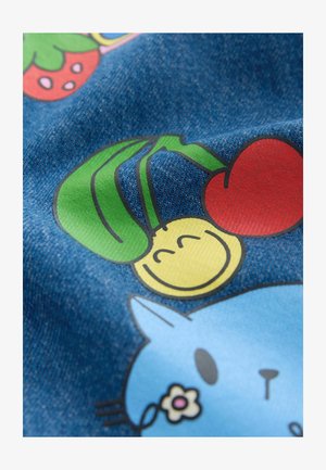Material din denim cu ilustrații colorate ce prezintă un chip galben zâmbitor, cireșe roșii și o pisică albastră cu o floare, pe un fundal albastru.