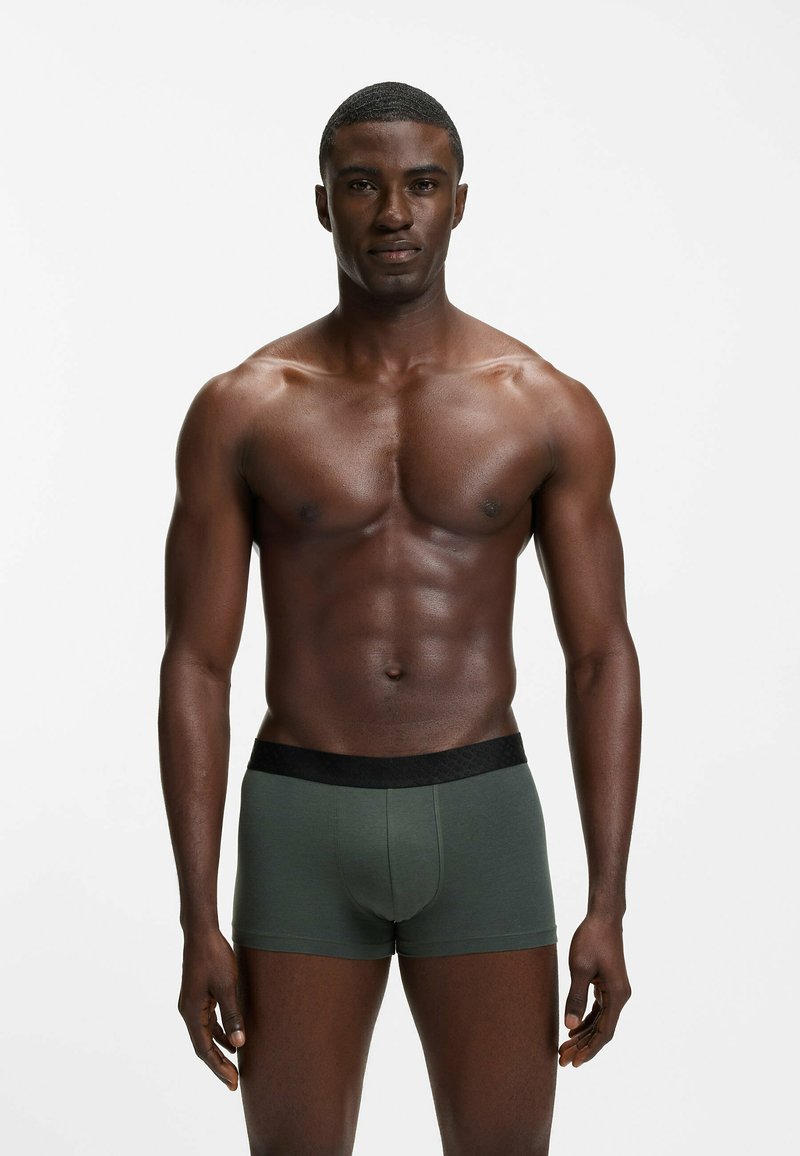 Men’s green modal boxer briefs with a black elastic waistband, featuring a fitted shape and soft, smooth texture.
