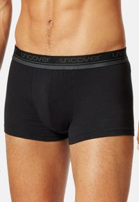 Boxer shorts neri in cotone con una cintura morbida che presenta il nome del marchio "uncover" in grigio. Offrono una vestibilità aderente e un design minimale.