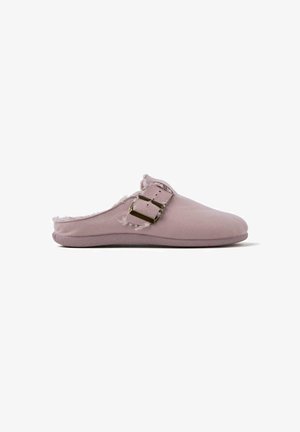 Zapato de ante rosa de tipo slip-on con un interior suave, que presenta un detalle de hebilla dorada y un borde desgastado. Suela plana, punta redondeada.