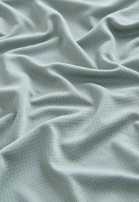 Helles blaues, strukturiertes Gewebe mit einem subtilen geometrischen Muster, das sanfte Drapierungen und ein weiches Finish aufweist, ideal für verschiedene Anwendungen.