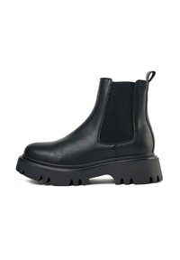 Black Chelsea boots made of synthetic leather with elastic side panels, rounded toe, and a rugged, chunky rubber sole.
