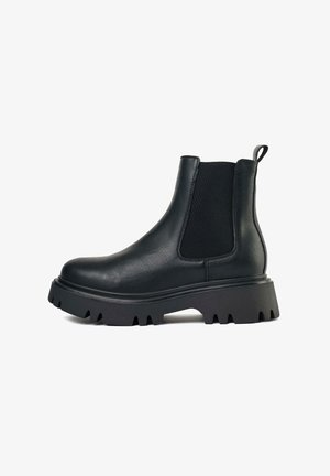 Black Chelsea boots made of synthetic leather with elastic side panels, rounded toe, and a rugged, chunky rubber sole.