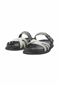 Schwarz-weiße Sandalen mit einem glatten Lederoberteil und ausgestanzten Designs, kontrastierenden strukturierten Riemen und einer robusten Gummisohle.