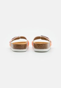 Tongs orange avec semelles en liège et fonds en caoutchouc blanc. Design ouvert à l'arrière, avec une semelle intérieure lisse et une sangle ajustable.
