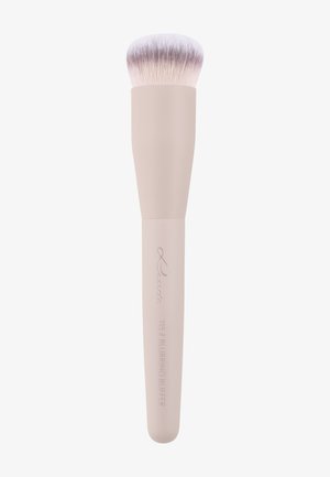 Pinceau à maquillage doux et dense avec un manche beige pâle étiqueté "115 Blurring Buff’r" et des poils effilés rose clair, utilisé pour estomper le maquillage.
