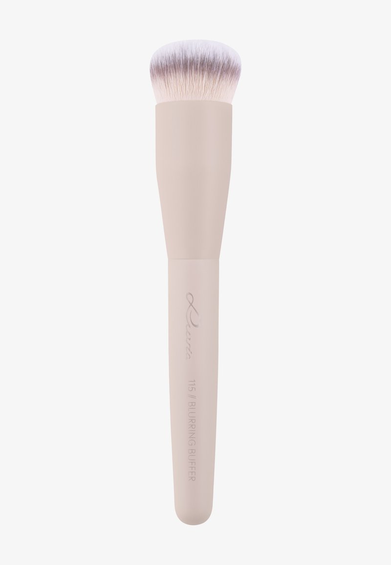 Pinceau à maquillage doux et dense avec un manche beige pâle étiqueté "115 Blurring Buff’r" et des poils effilés rose clair, utilisé pour estomper le maquillage.