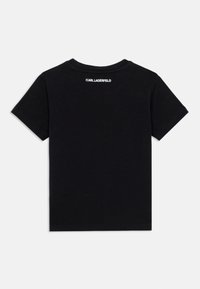 Μαύρο βαμβακερό T-shirt με στρογγυλή λαιμόκοψη, κοντά μανίκια και λευκό κείμενο που διαβάζει "KARL LAGERFELD" στο πάνω μέρος της πλάτης.