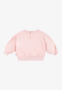 Roza obrezana jopa z dolgimi napihnjenimi rokavi in rebrastimi manšetami. Ima okrogel izrez in detajl z zapiranjem na hrbtni strani. Izdelana iz mehke tkanine.