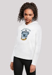 Felpa bianca con il crest di Ravenclaw, con dettagli grafici in blu e oro. Ha una tasca a marsupio e un cappuccio regolabile con cordino.