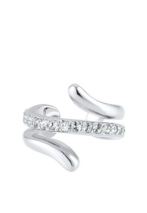 Bague ouverte argentée avec une rangée de cristaux ronds clairs le long du centre, avec des extrémités lisses et courbées, présentée sur un fond blanc.