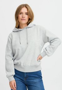 Világosszürke kapucnis pulóver, pamut keverékb�ől készült, amely állítható kapucnival, bordázott mandzsettákkal és aljjal rendelkezik, laza szabású, zsebével.