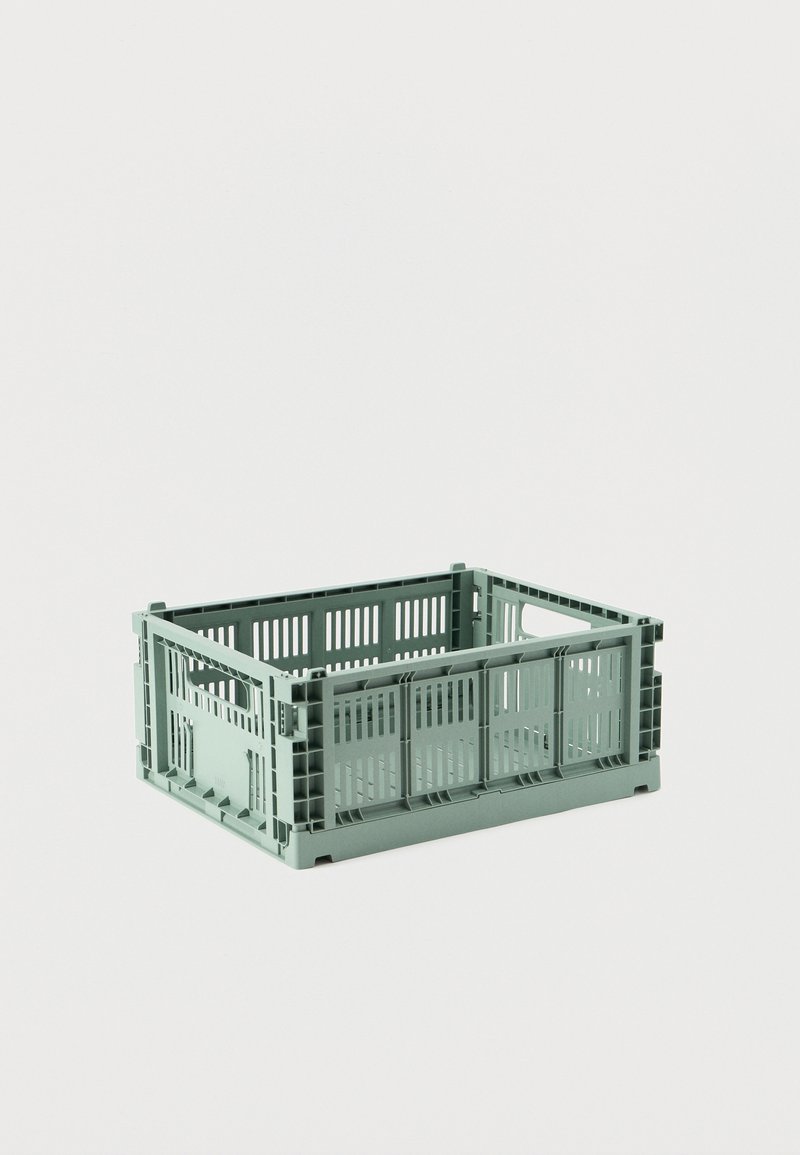 Πλαστικό ορθογώνιο κουτί αποθήκευσης ανοιχτού πράσινου χρώματος με οπές αερισμού και πλευρικές χειρολαβές σε απλό φωτεινό φόντο.