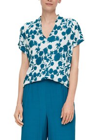 Korte mouwen blouse met een teal bloemenpatroon op een witte achtergrond, voorzien van een V-hals en een ontspannen pasvorm. Soepele stof en vloeiende uitstraling.