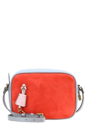 Sac bandoulière rectangulaire avec panneau avant rouge vif, bords et sangle gris clair, et petite étiquette rose attachée à l'avant.