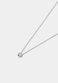 Sølv kædedesign med en cirkulær vedhæng, der har en klar, facetteret ædelsten i midten. Enkel design, poleret finish.