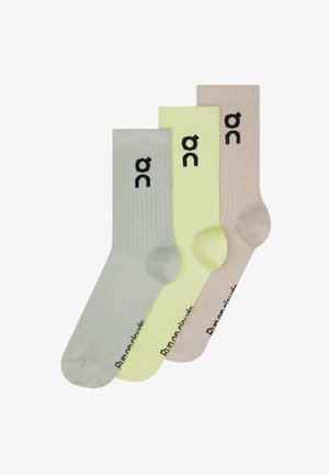 Trei perechi de șosete cu dungi, în gri deschis, verde lime și bej, cu logo negru lângă marginea manșetei. Textură netedă, lungime până la jumătatea gambei.