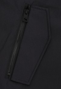 Tessuto nero con una texture liscia presenta una tasca con zip angolata, che mette in mostra accessori neri eleganti. Il design è minimalista e funzionale.