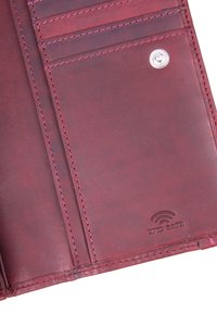 L'interno del portafoglio in pelle bordeaux presenta scomparti per carte e una stampa RFID Safe. La texture è liscia con dettagli di cucitura a contrasto.