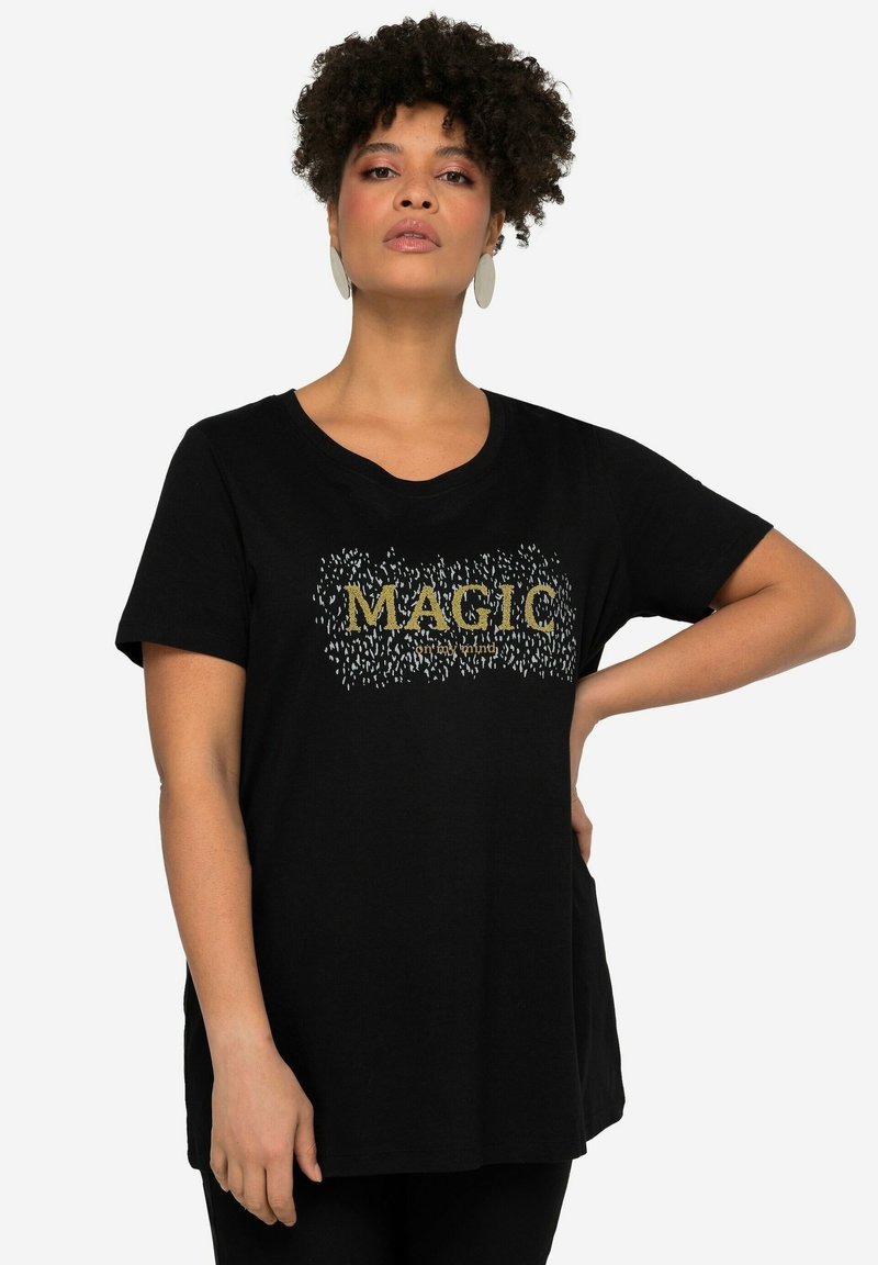 Černé bavlněné tričko s krátkými rukávy, které má zlatou grafiku "MAGIC" a texturovaný vzor kolem písmen. Kulatý výstřih.
