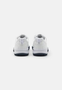 Adidași albi cu talpă bleumarin, un inserție din plasă texturată, guler căptușit și bandă la călcâi pentru o încălțare ușoară.