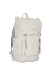 Light beige canvas backpack with a roll-top design, mesh side pockets, front zip pocket, and embossed logo detail. Features adjustable straps.