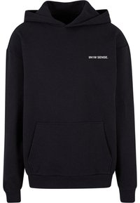 Mustast sweatshirt, mis on valmistatud puuvilla ja sünteetilise kiu segust, esiosa taskuga, ribatud mansettide ja alumise äärega. Rinna peal on valgete kirjaga broderitud "9N1M SENSE."