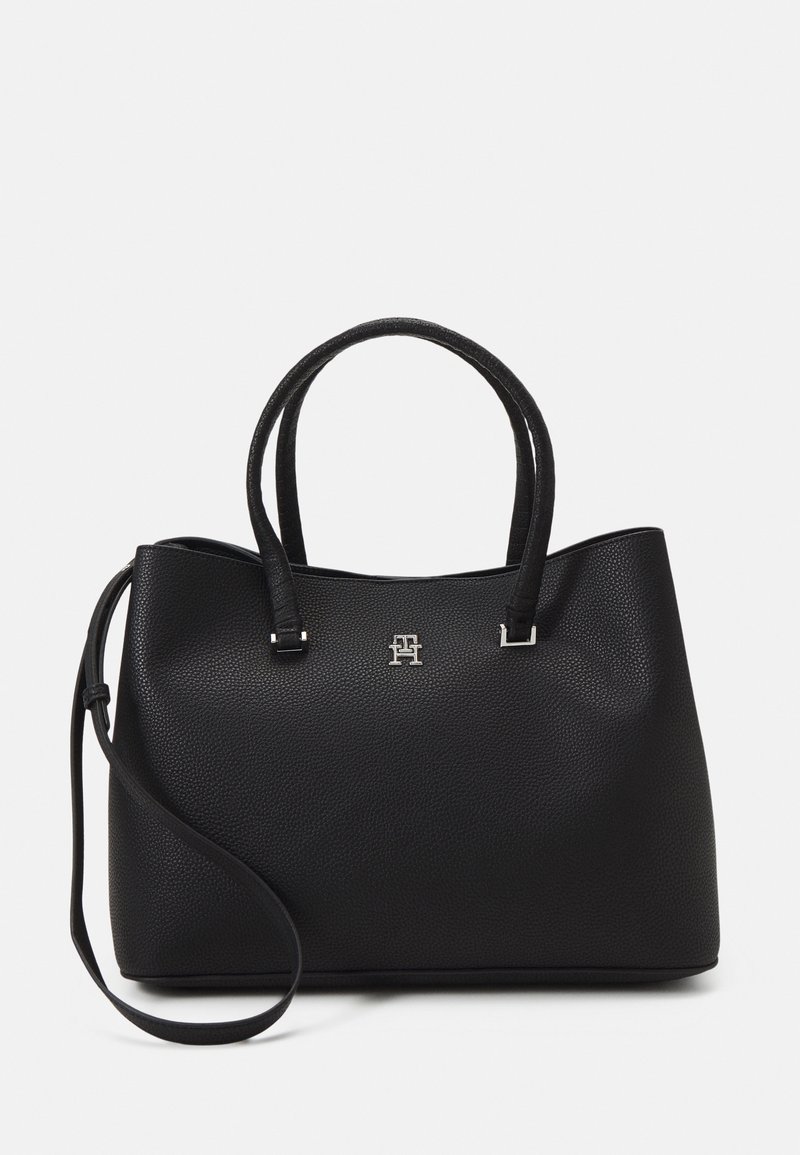 Bolso tote de cuero negro con un acabado texturizado, que cuenta con dos asas cortas y una correa para el hombro desmontable. Detalle del logo en plata en la parte frontal.