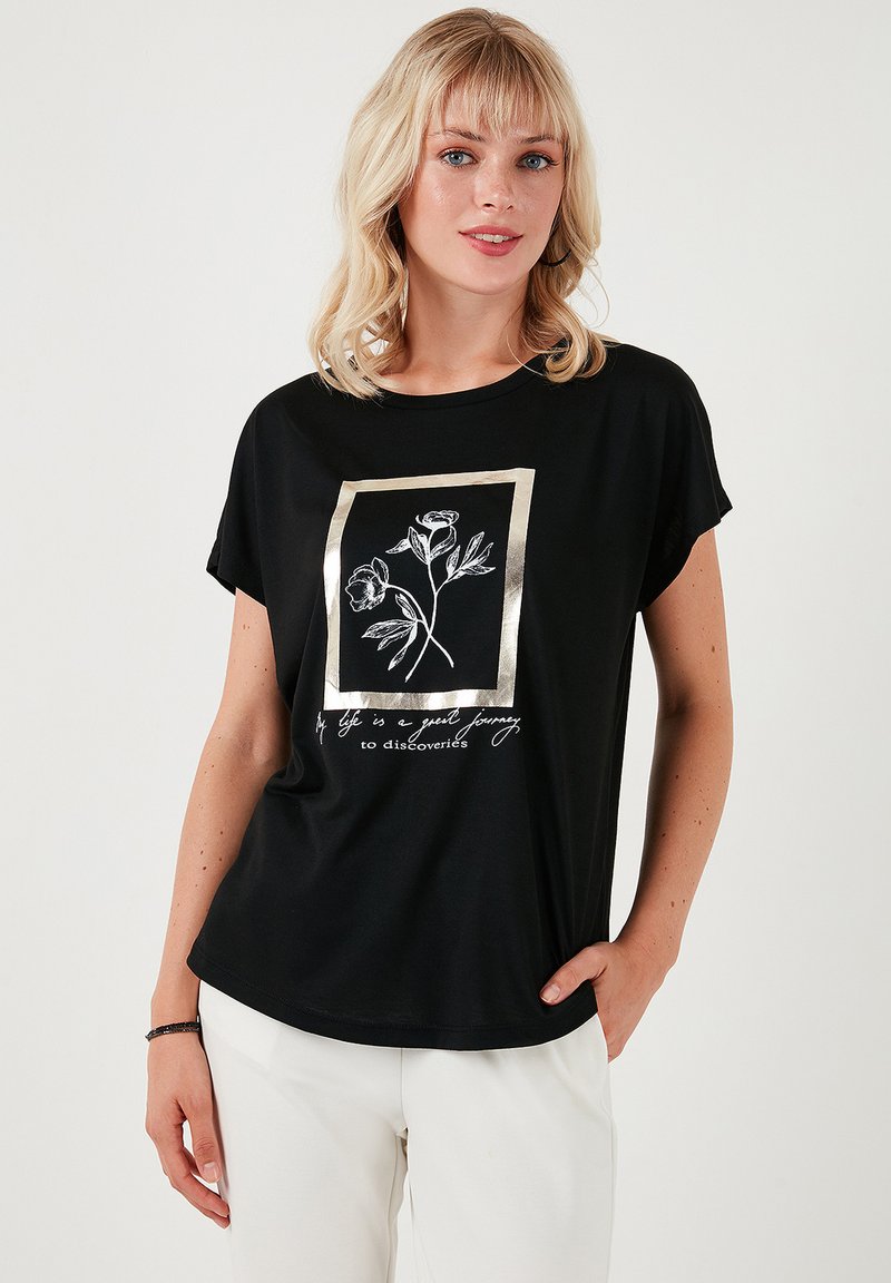 Zwarte T-shirt met korte mouwen, gekenmerkt door een metalen gouden omlijsting van een bloemmotief en witte tekst. Gemaakt van een zachte, lichtgewicht stof.