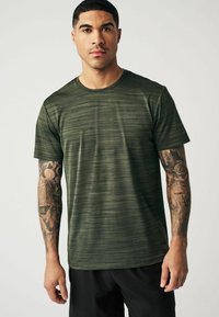 Grønstribet trænings-T-shirt med rund hals, korte ærmer og en blød tekstur. Har en vinkelret søm ved kanten.