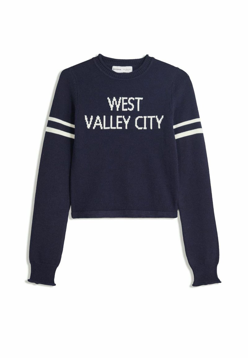 Mornja tamnoplava kratka dukserica s dugim rukavima s bijelim natpisom "WEST VALLEY CITY" i dvije bijele pruge na svakoj rukavu.