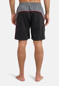 Μαύρα και γκρι μαγιό με κορδόνι στη μέση, κόκκινη επένδυση και πλαϊνή τσέπη αριστερά. Λείο ύφασμα, μήκος μέχρι το γόνατο.