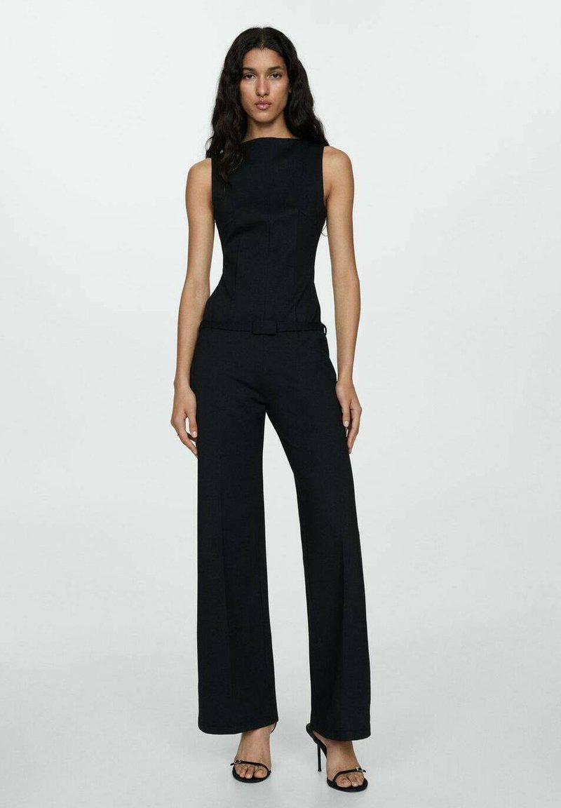 Čierny overal s priliehavým telom a širokými nohavicami. Má vysoký golier a úzky opasok v páse. Textúrovaná tkanina.
