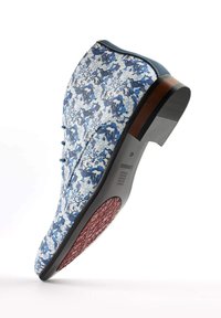 Floral-patterned blue and white boot with a rounded toe, blue leather accents, and a textured red rubber sole.