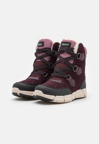 Waterdichte mid-top laarzen in bordeauxrood en zwart suede, met roze accenten, ronde veters met een stippenpatroon, en een gestructureerde rubberen zool.