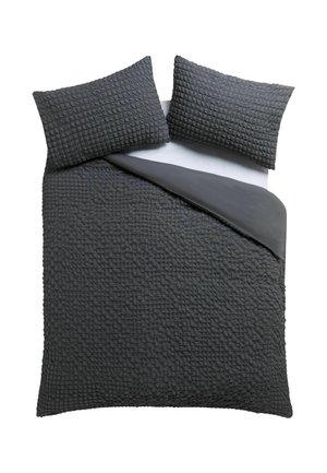 Dunkelgraues, strukturiertes Decken-Set mit zwei passenden Kissenbezügen auf einem Bett, eine Ecke zurückgefaltet, um die glatte Unterseite zu zeigen.
