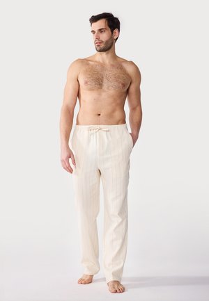 Pantalons de lounge beige clair avec de fines rayures verticales, dotés d'une taille élastique à cordon de serrage et de poches latérales, fabriqués en tissu doux.