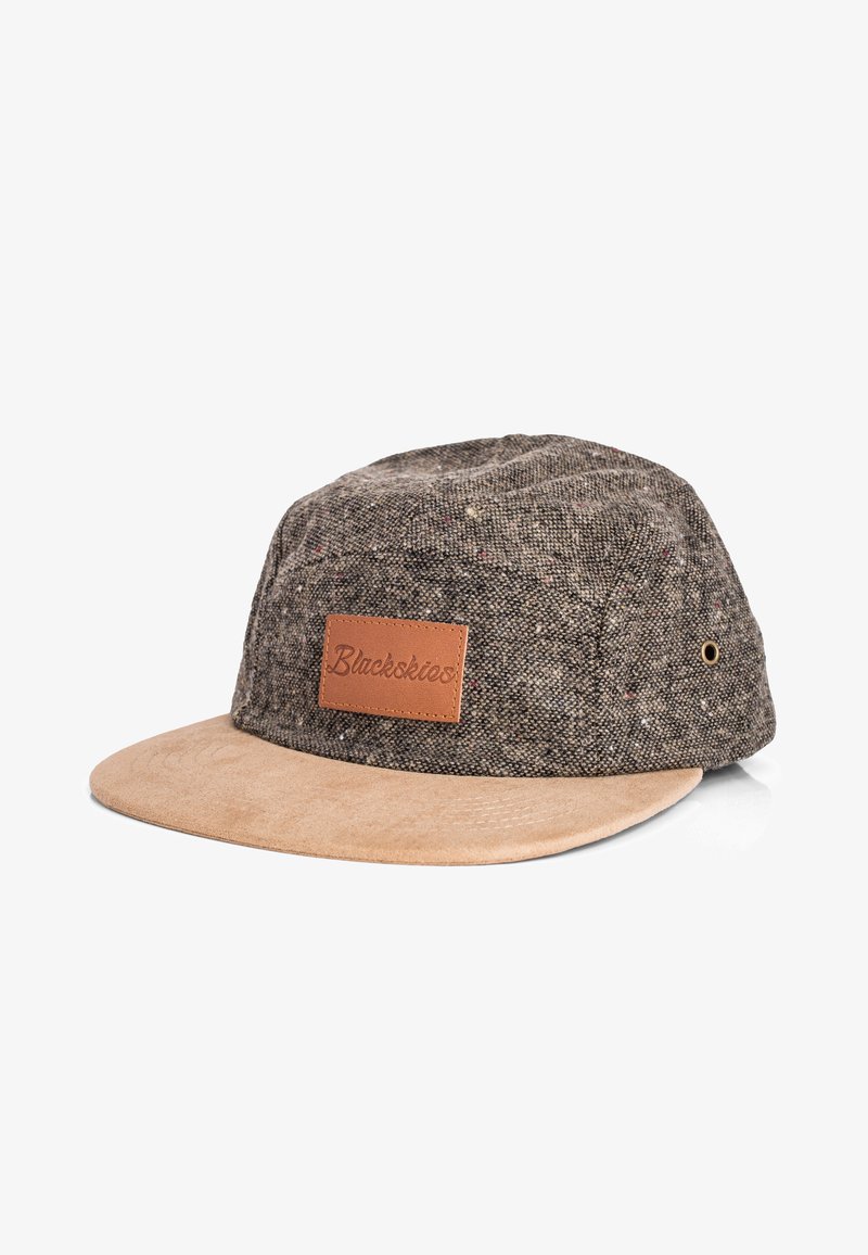 Brown patterned fabric cap with a suede beige brim and a leather patch label. Features metal ventilation eyelets on the sides.