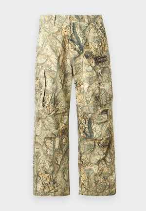 Spodnie cargo moro w ziemistych odcieniach z motywem liści i drzew. Posiadają liczne kieszenie oraz luźny, swobodny krój. Wykonane z trwałego materiału.