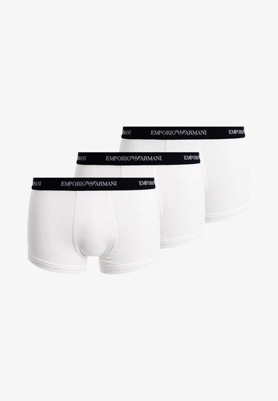 Tres pares de calzoncillos de algodón blancos con una cinturilla elástica negra que presenta el logo "Emporio Armani" en blanco.