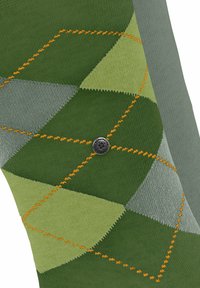 Calzini verdi e grigi a motivo, con un design a rombi e cuciture arancioni, e un logo circolare su un lato.