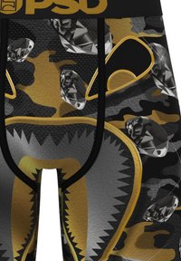 Primo piano di pantaloncini mimetici neri e oro con motivi a diamante e una faccia di orso stilizzata contornata in oro e grigio.