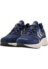 Marinblå atletiska skor tillverkade av mocka och nät, med en texturerad ovandel, svart gummisula och tre diagonala ränder i grått.